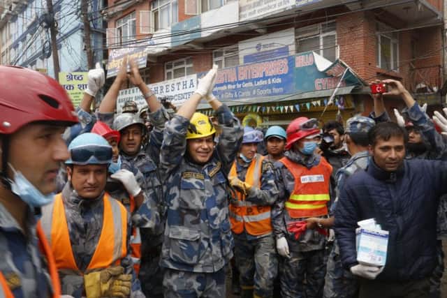 Nepalese policemen cheer after Pemba Tamang is pulled alive from the rubble. Picture: AP