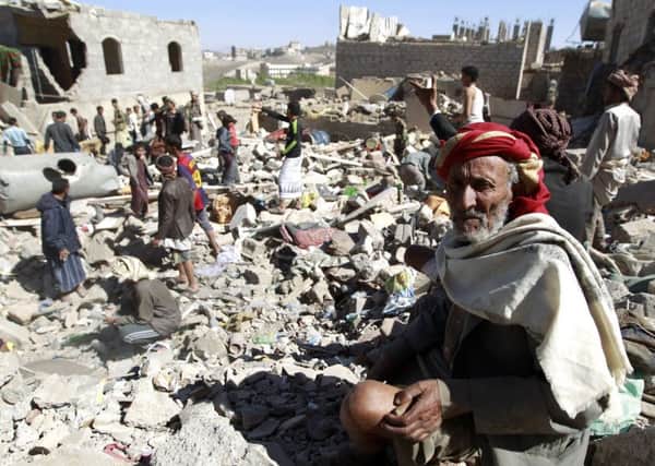 A Yemeni man sits on the rubble as people search for survivors in houses destroyed by an overnight Saudi air strike. Picture: Getty