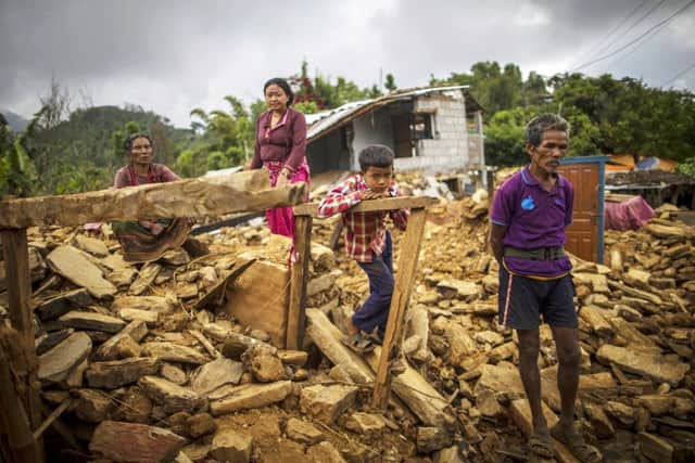 Dejected locals stand in the ruins of their homes in Paslang village in Gorkha in central Nepal. Picture: AFP/Getty