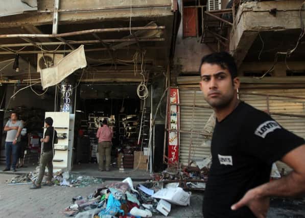 An Iraqi man looks on as he stands in front of a damaged shop in Baghdads Karrada area yesterday. Picture: Getty