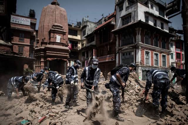 Members of the Nepalese police clear debris from Dunbar square in Kathmandu. Picture: Philippe Lopez