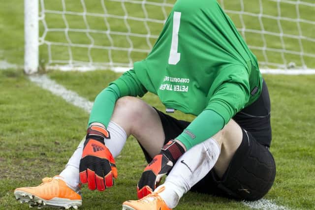 Edinburgh City goalkeeper Andrew Stobie hides under his jersey after losing to Brora Rangers on penalties. Picture: Ken Macpherson