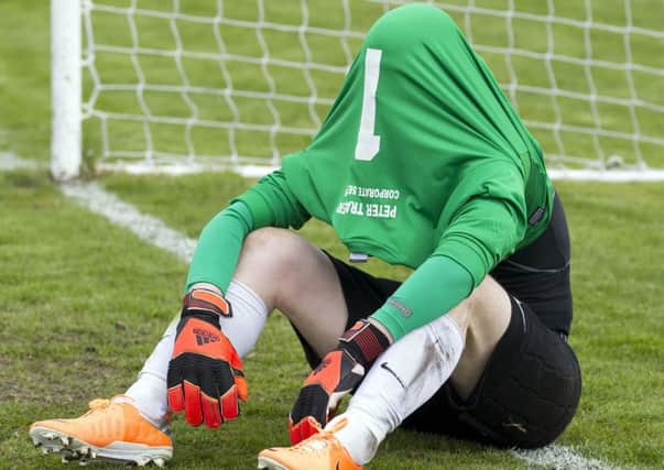 Edinburgh City goalkeeper Andrew Stobie hides under his jersey after losing to Brora Rangers on penalties. Picture: Ken Macpherson