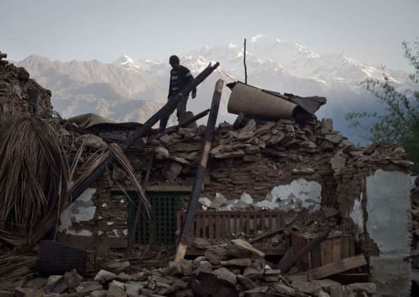 A villager walks on the roof of his destroyed house in Barpak village in north central Nepal. Picture: AFP