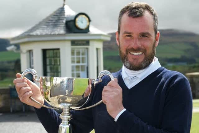 Chris Kelly holds the trophy aloft after defeating Paul McKechnie at the first extra hole. Picture: Andy Forman