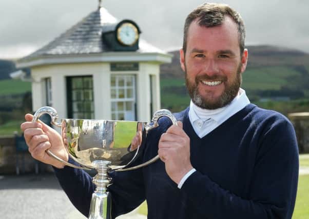 Chris Kelly holds the trophy aloft after defeating Paul McKechnie at the first extra hole. Picture: Andy Forman