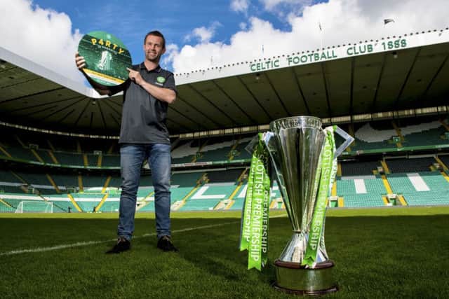 Ronny Deila with the Premiership trophy which was secured while he was in Norway, attending his daughters' confirmation. Picture: SNS