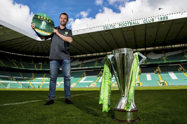 Ronny Deila with the Premiership trophy which was secured while he was in Norway, attending his daughters' confirmation. Picture: SNS