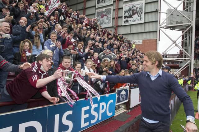 Hearts manager Robbie Neilson shows the Scottish Championship trophy to fans at Tynecastle. Picture: PA