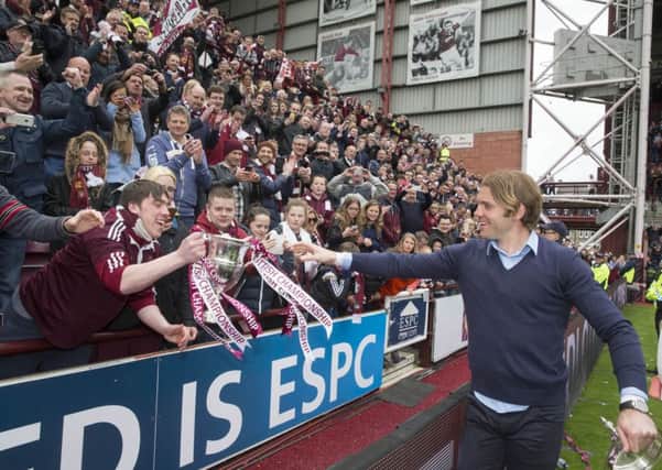 Hearts manager Robbie Neilson shows the Scottish Championship trophy to fans at Tynecastle. Picture: PA