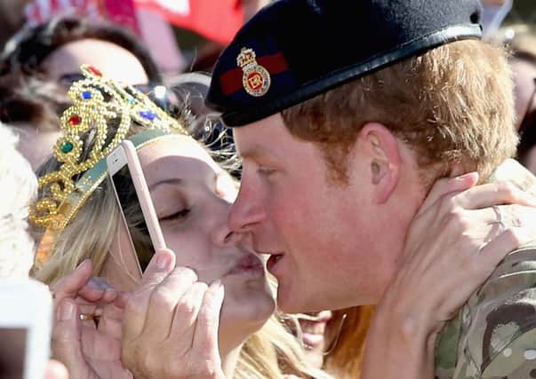 Prince Harry gets kissed by Royal Fan Victoria Mcrae during a walkabout outside the Sydney Opera House. Picture: Getty