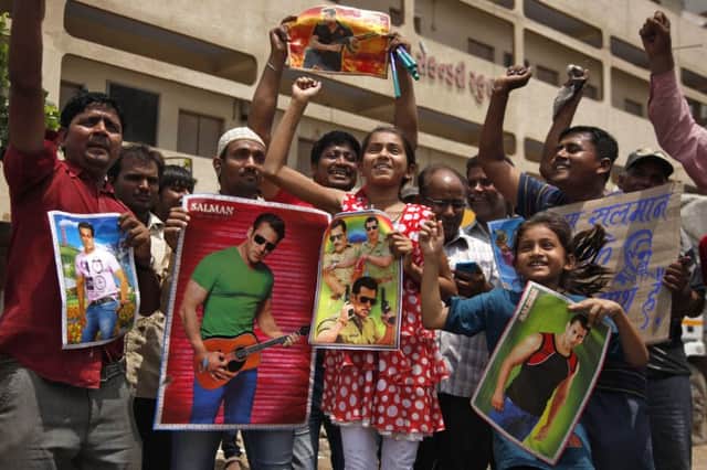 Fans hold posters of Bollywood actor Salman Khan as they celebrate in Ahmadabad. Picture: AP