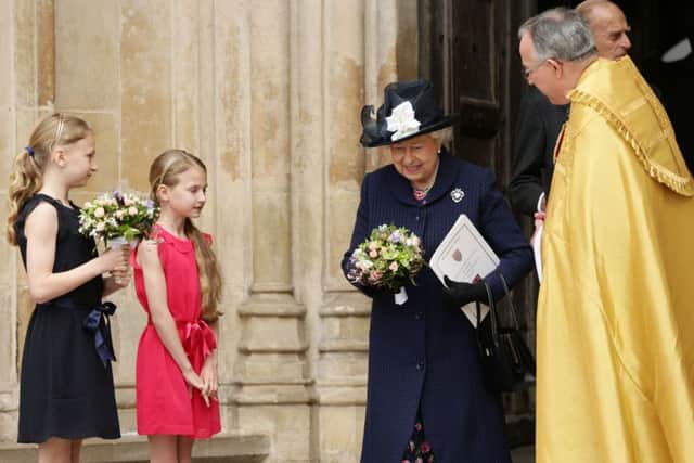 Queen Elizabeth II  is presented with flowers as she leaves the Service. Picture: PA