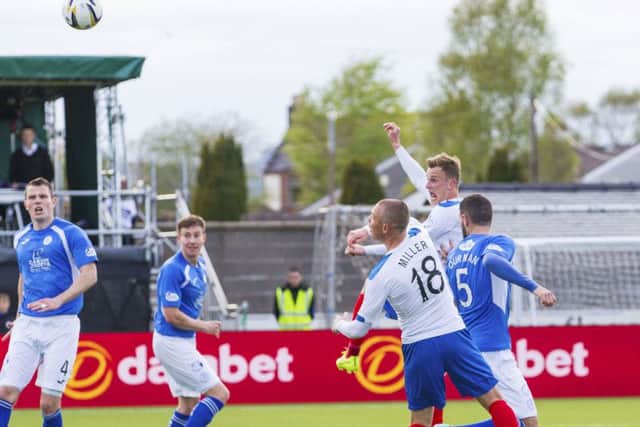 Rangers' Dean Shiels, second from right, rises high above the Queen of the South. Picture: SNS