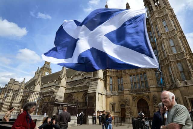 Phil Green, a former city councillor in Glasgow, flies the Saltire to welcome Scottish National Party leader Nicola Sturgeon and the SNP's 56 new members of parliament outside the Houses of Parliament. Picture: PA