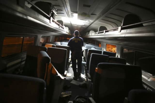 A crime scene investigator takes notes inside one of the carriages. Picture: AP