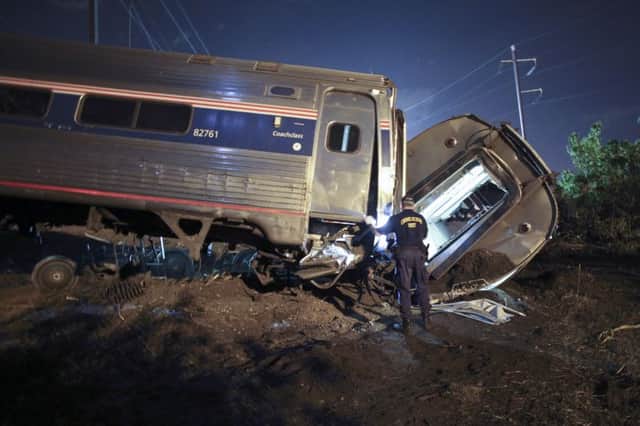 An emergency services worker stands near part of the wreckage of train 188. Picture: AP