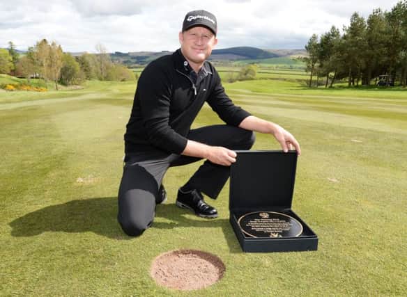 Jamie Donaldson with the plaque marking the spot from where he hit the winning shot in last year's Ryder Cup at Gleneagles. Picture: SNS
