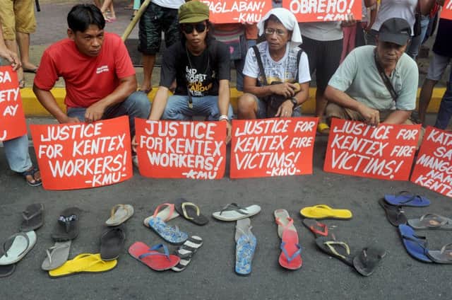 Protesters display sandals during a rally to call for justice for the victims of this weeks fire in Manila. Picture: AFP/Getty