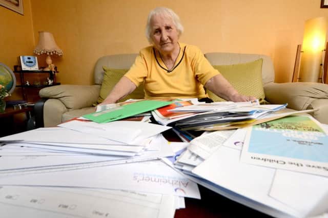 Olive Cooke pictured at her home in Bristol with piles of junk and charity mail. Picture: SWNS