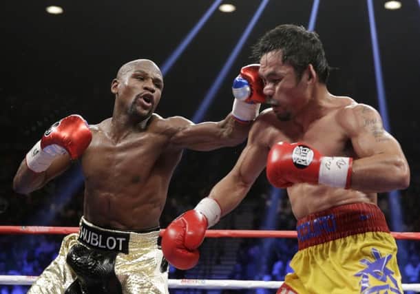 Floyd Mayweather Jr, left, hits Manny Pacquiao, during their welterweight title fight in Las Vegas earlier this month. Picture: AP