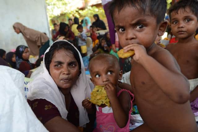 Rescued Rohingya women and children are provided with food by Indonesian residents in the compound of a mosque in Julok district, Aceh province. Picture: Getty