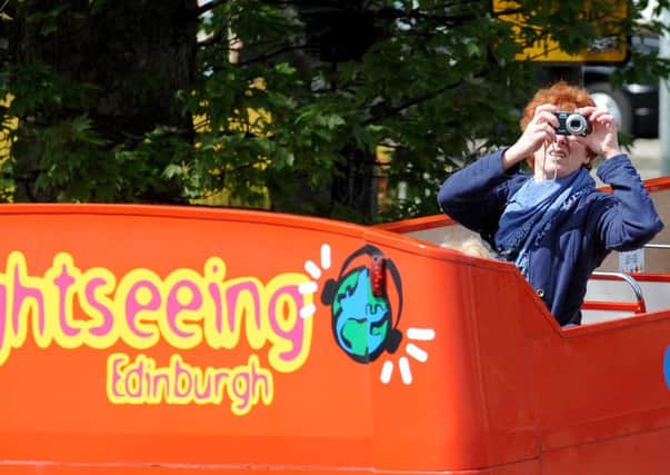 A tourist takes in her surroundings on an open top bus in Edinburgh. Picture: Jane Barlow