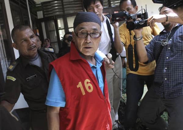 Japanese national Masaru Kawada, center, is mobbed by the media upon arrival for his sentencing hearing at the district court in Pariaman, West Sumatra, Indonesia. Picture: AP