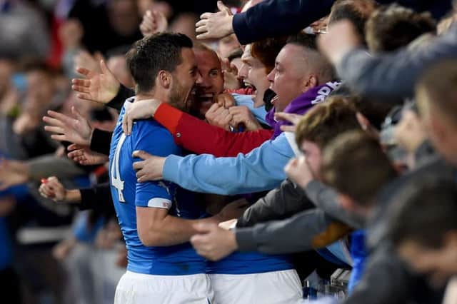 Rangers fans celebrate with goalscorer Kenny Miller, centre, and Nicky Clark, left after he doubles his side's lead. Picture: SNS