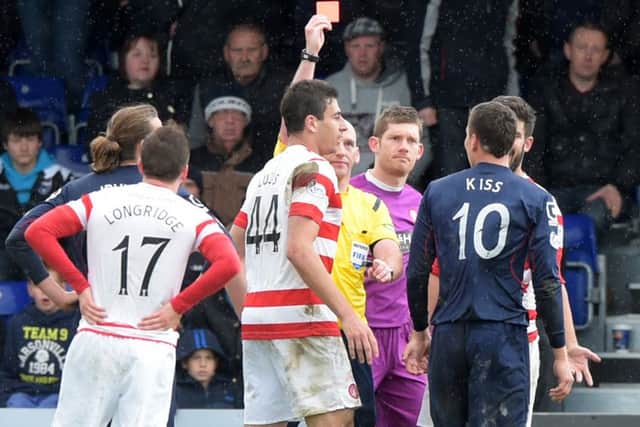 Ross County's Filip Kiss is shown the red card by referee Bobby Madden. Picture: SNS