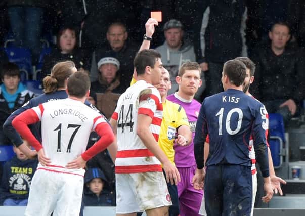 Ross County's Filip Kiss is shown the red card by referee Bobby Madden. Picture: SNS
