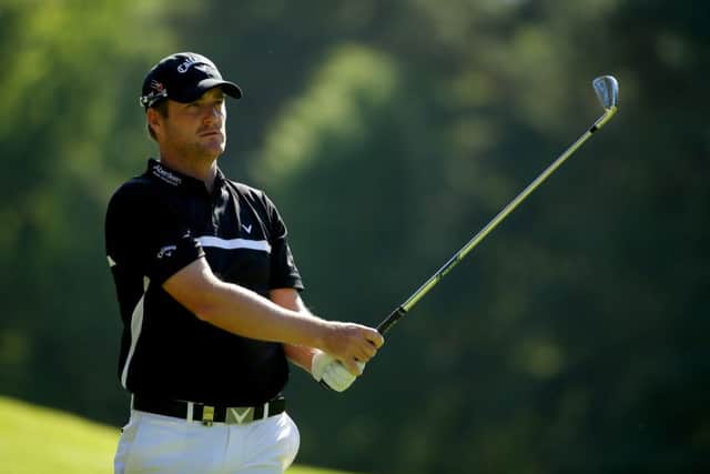 Marc Warren of Scotland hits a shot on the 13th hole during yesterdays opening round of the BMW PGA Championship at Wentworth. Picture: Getty