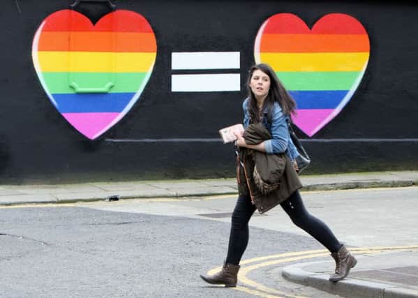 A woman walks past a mural in favour of same-sex marriages in Dublin. Ireland will today vote on gay marriage. Picture: Getty