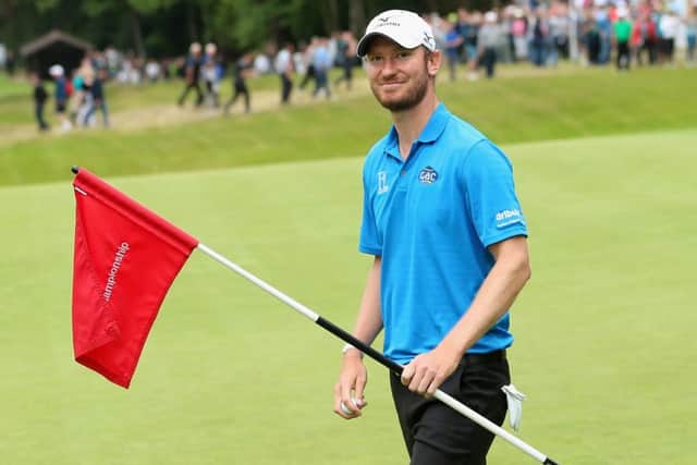 Chris Wood collects his ball after his BMW-winning hole in one. Picture: Getty