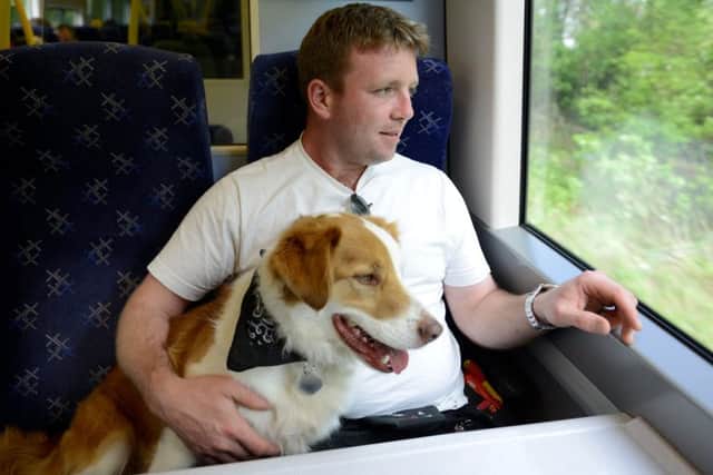 Thomas McCormack, with his dog Paddy on the train. Picture: Hemedia