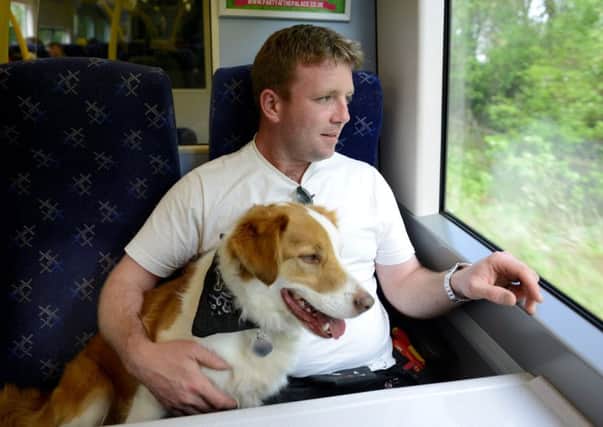 Thomas McCormack, with his dog Paddy on the train. Picture: Hemedia