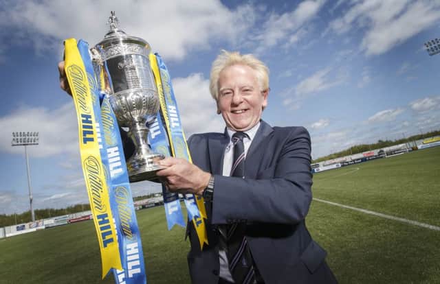 Falkirk chairman Dougie Henderson gets his hands on the cup. Picture: Steve Welsh