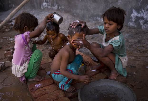 Children wash in the water from a public tap. Picture: AP
