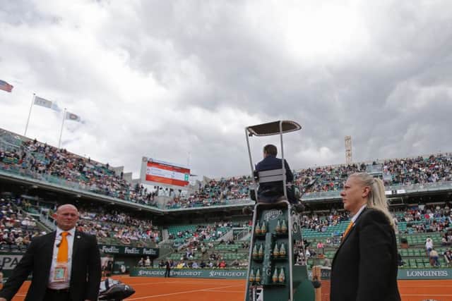 Two security guards keep an eye on the spectators after a fan ran onto the court. Picture: AP