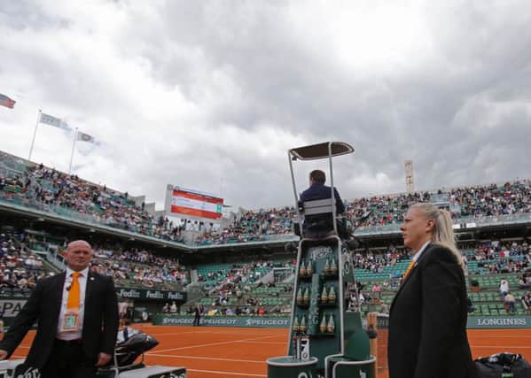 Two security guards keep an eye on the spectators after a fan ran onto the court. Picture: AP