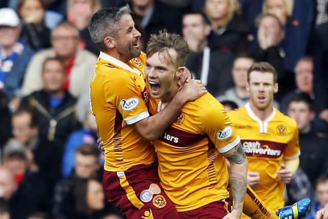 Lee Erwin, centre, celebrates his opening goal in Motherwells 31 Premiership playoff final first leg win at Ibrox. Picture: Danny Lawson/PA