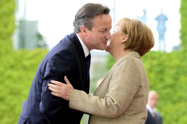 Angela Merkel greets David Cameron before their talks in Berlin yesterday. Picture: Getty