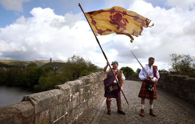Wallace Society member Malcolm McNeill (left) from Strachur waves a Lion Rampant flag on Stirling Bridge. Picture: PA