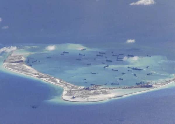 Chinese dredging vessels are seen in the waters around Mischief Reef in the disputed Spratly Islands in the South China Sea. Picture: PA