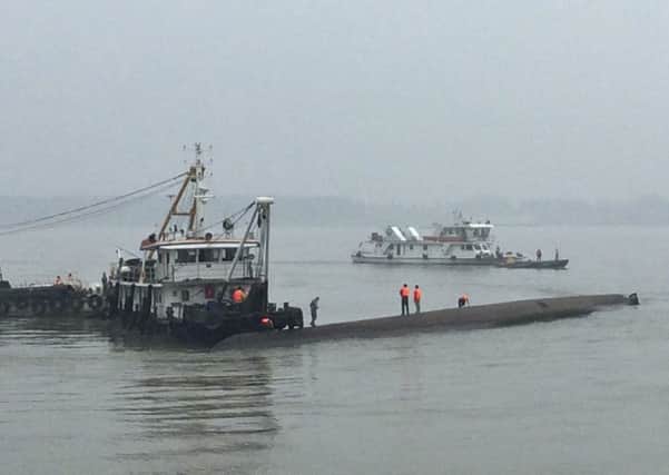 Rescue workers stand on the capsized ship on the Yangtze River in central China's Hubei province. Picture: AP