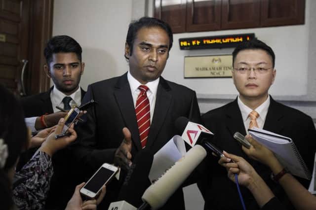 The familys lawyer Arunan Selvaraj, centre, at the court in Kuala Lumpur. Picture: AP