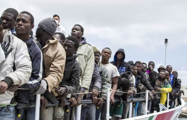 Migrants wait to disembark from the Italian Coast Guard ship Peluso, on the tiny Italian island of Lampedusa.  Picture: AP