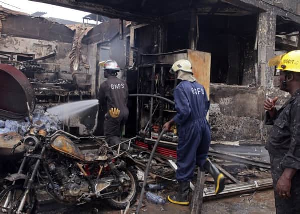 Firefighters spray water over the smoldering remains a gas station following an explosion in Accra, Ghana. Picture: AP