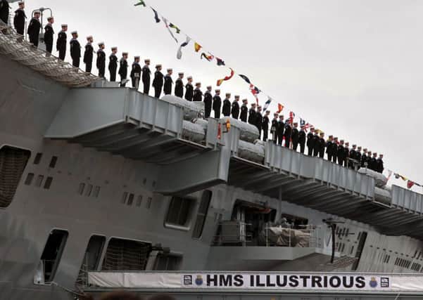 The crew of HMS Illustrious stand at ease during the naming ceremony for the aircraft carrier Queen Elizabeth at Rosyth in Fife last year. Picture: Getty