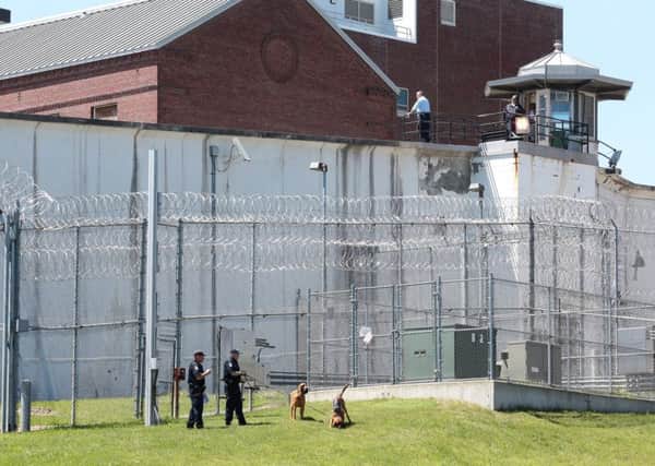 Law enforcement officers with bloodhounds stand guard at one of the entrances to the Clinton Correctional Facility in New York state Picture: AP